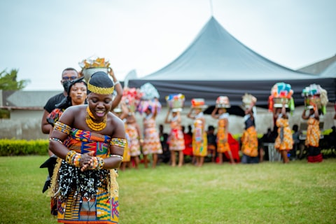Traditional wedding dance troupe in beaded headpieces and patterned wraps performing outdoors